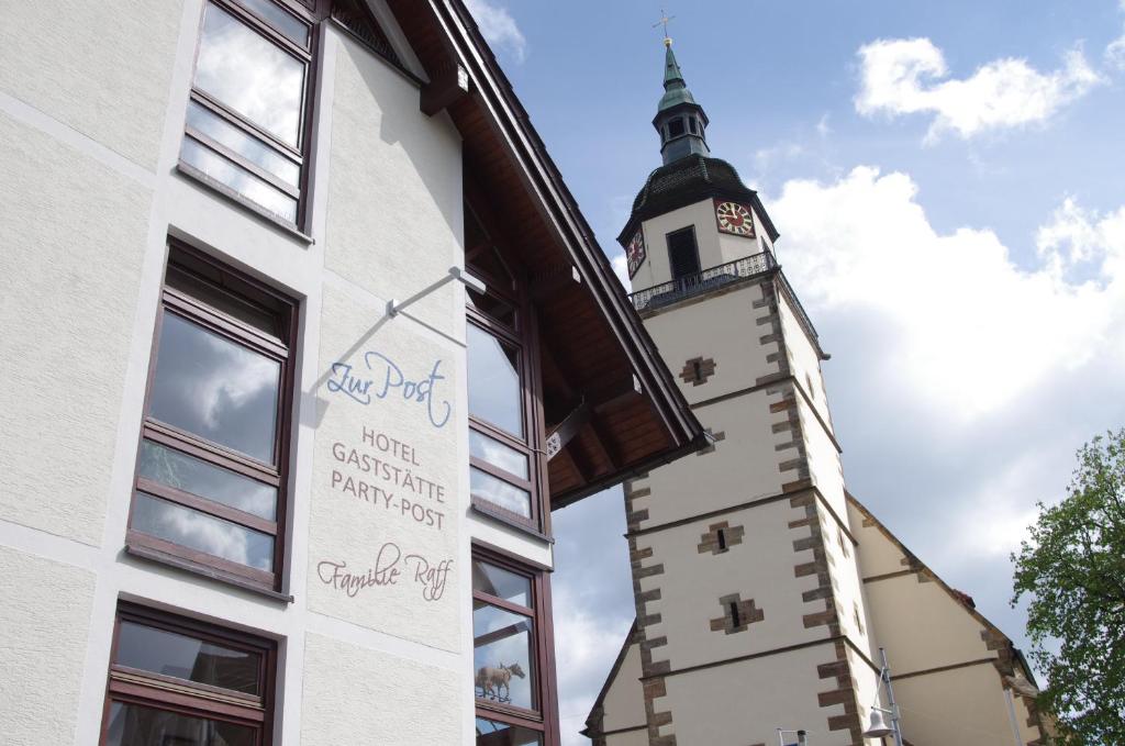 un edificio con una torre de reloj a un lado en Hotel zur Post en Weilheim an der Teck