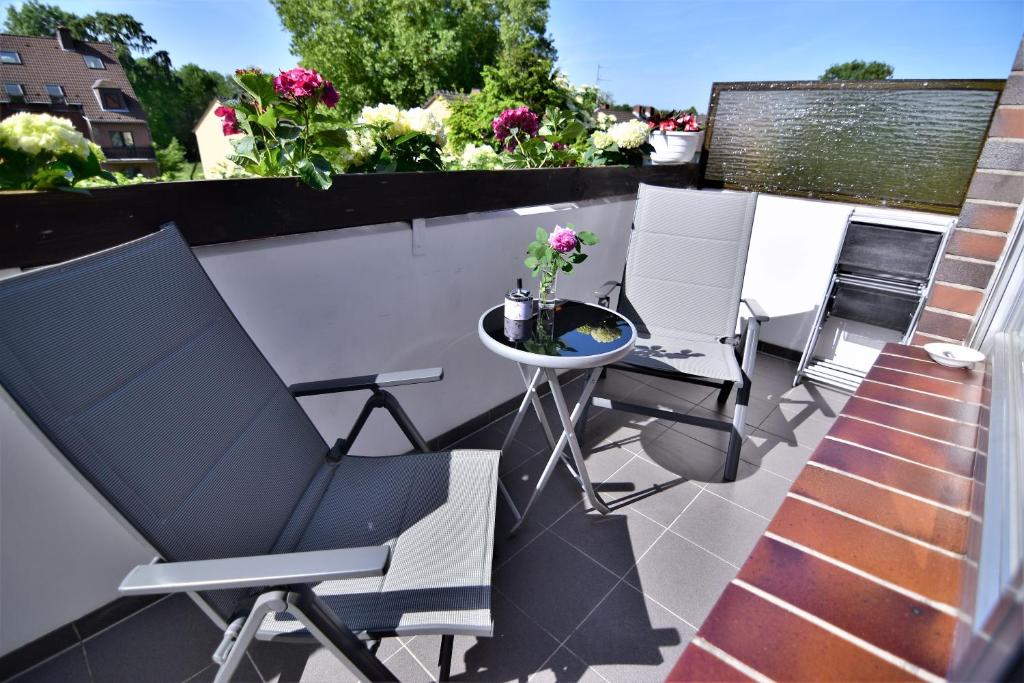 eine Terrasse mit Stühlen und einem Tisch auf dem Balkon in der Unterkunft Apartments Neuss in Neuss