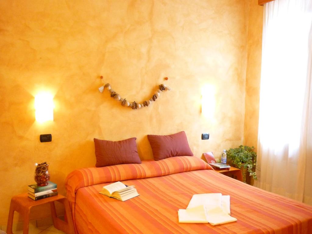 1 dormitorio con 1 cama grande de color naranja con libros. en Antica Corte, en Lucca