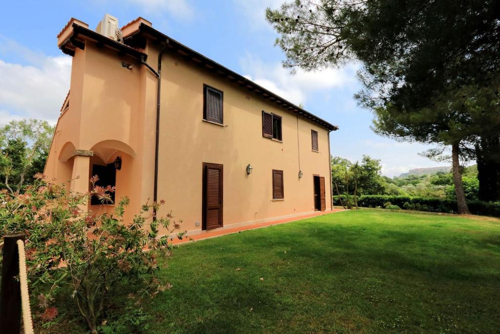 a house with a large yard in front of it at Agriturismo Pimpinnacolo in Porto Ercole