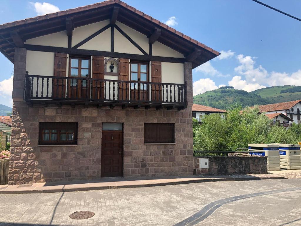 a small house with a balcony on top of it at Zubitarte in Elizondo