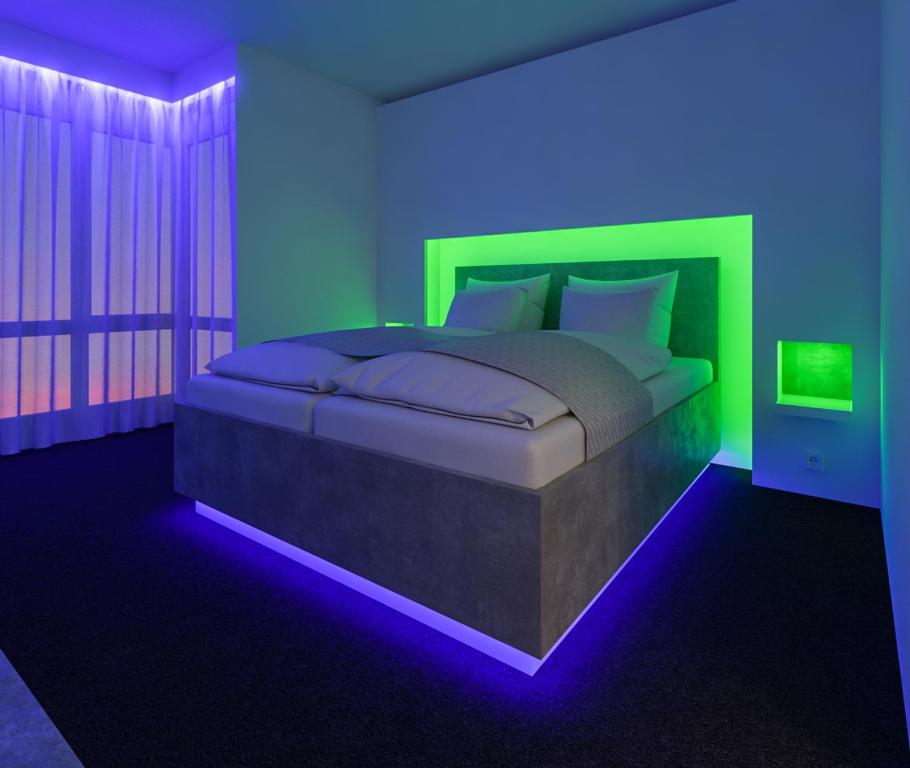 a bedroom with a bed with blue and green lights at smartel at The Unbrexit in Ahaus