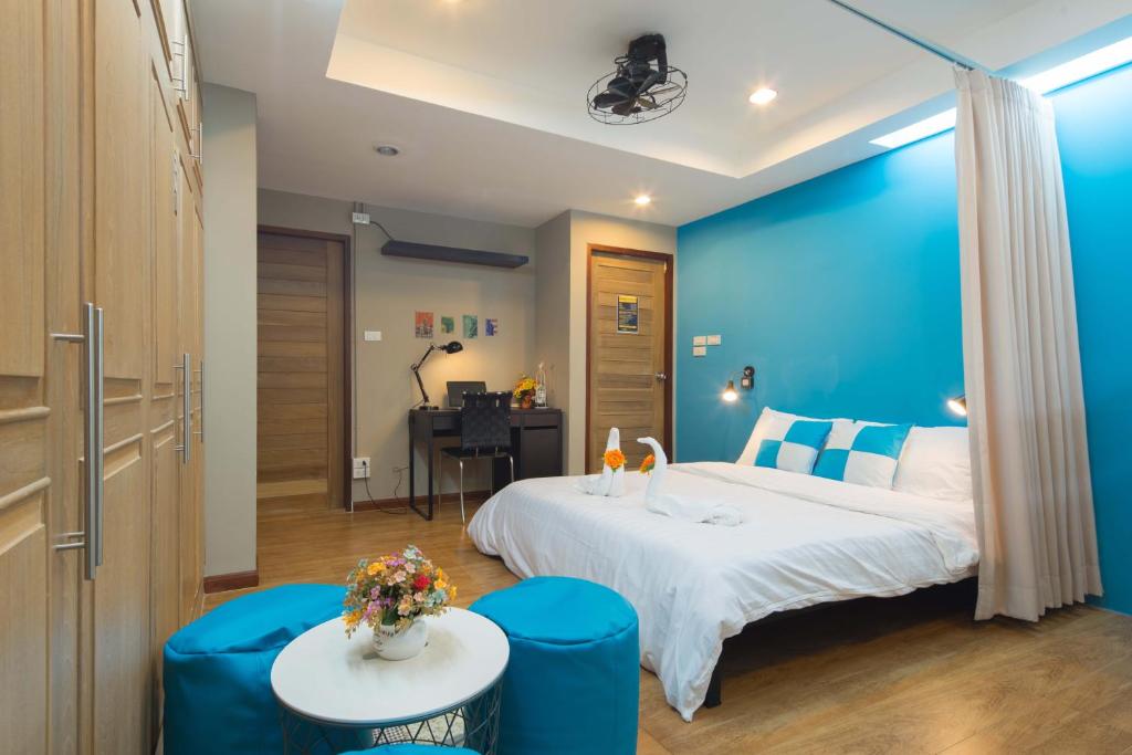 una camera d'albergo con un letto grande e una scrivania di Augusta a Bangkok