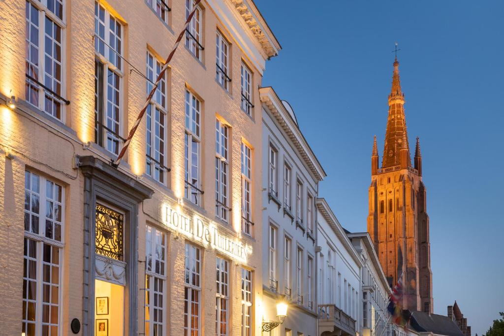 un bâtiment avec une tour d'horloge en arrière-plan dans l'établissement De Tuilerieën - Small Luxury Hotels of the World, à Bruges