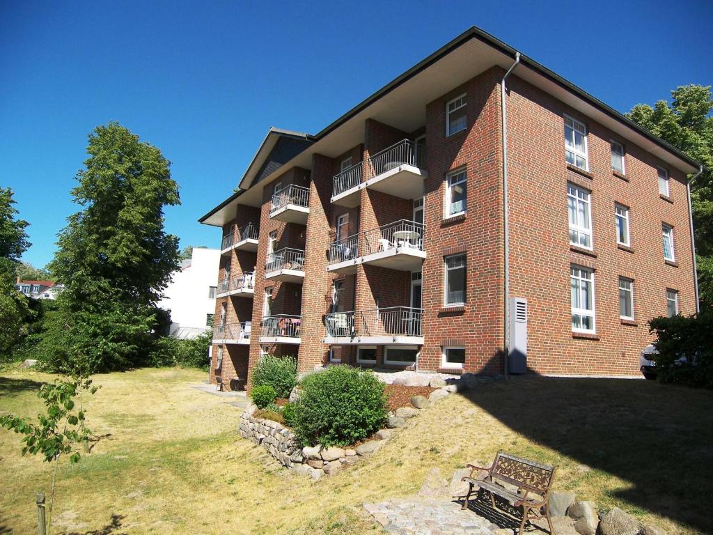 ein großes Backsteingebäude mit einer Rasenfläche davor in der Unterkunft Haus Roland- Whg 23 mit Schwimmbad und Sauna in Zinnowitz