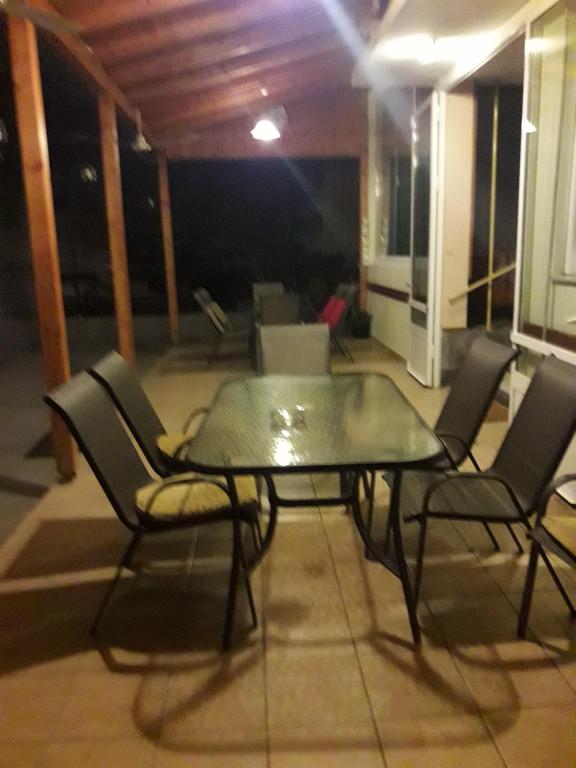 a glass table and chairs in a room at Nana Hotel in Kamena Vourla