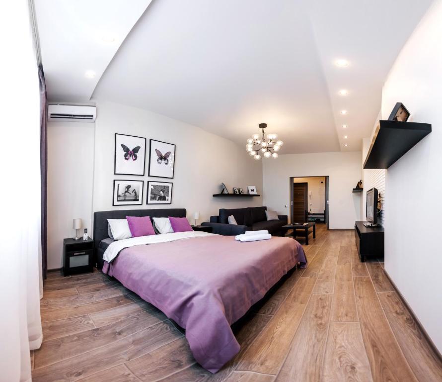 a bedroom with a large bed and a couch at Apartments on Malygina in Tyumen