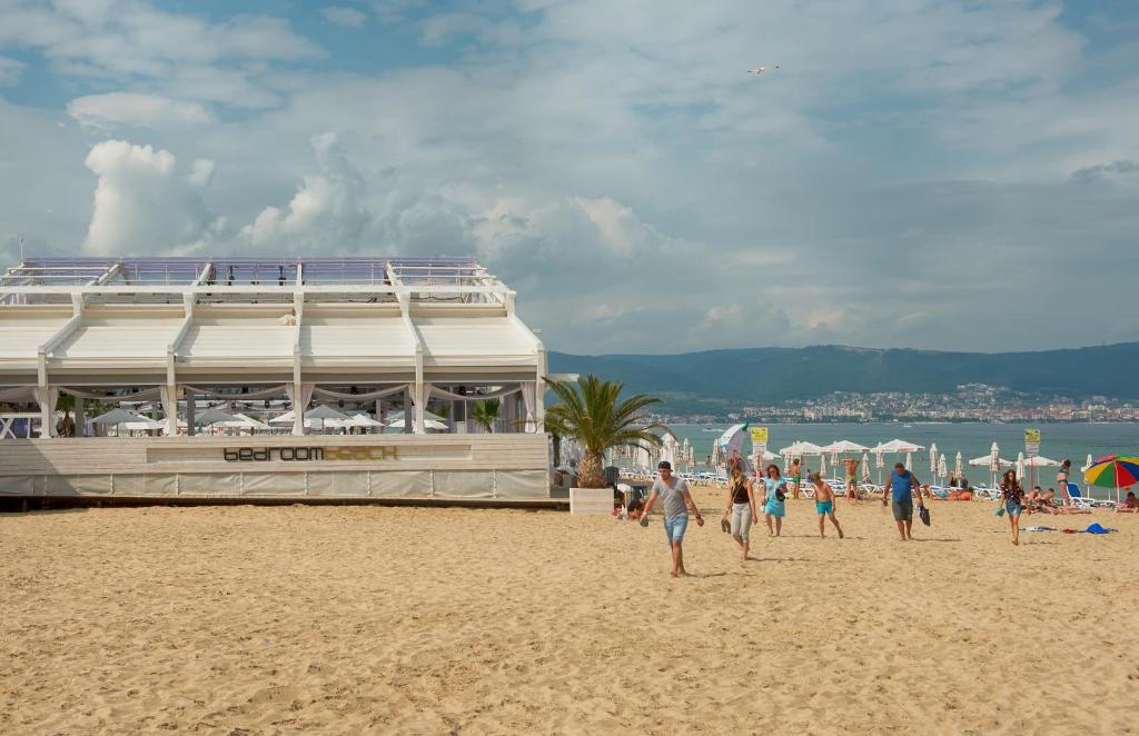 un grupo de personas caminando por la playa en Viva Apartments, en Sunny Beach