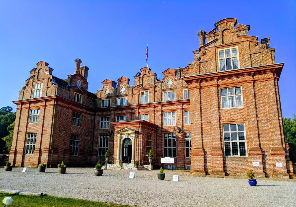 een groot gebouw van rode baksteen met een grote deuropening bij Broome Park Hotel in Canterbury