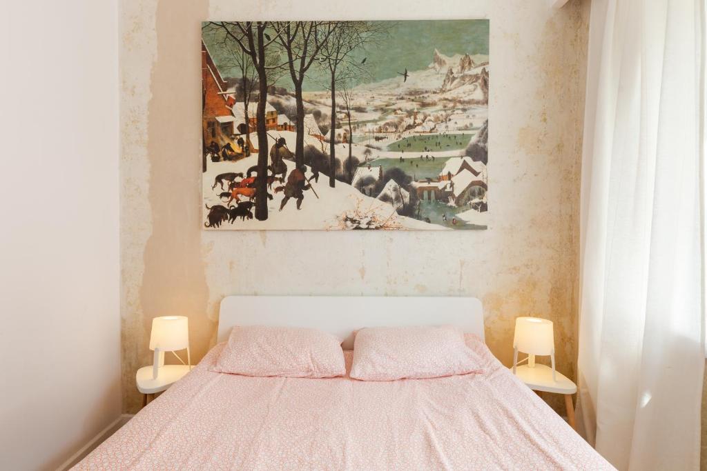 a bedroom with a bed with a painting on the wall at Apartament w sercu miasta in Łódź