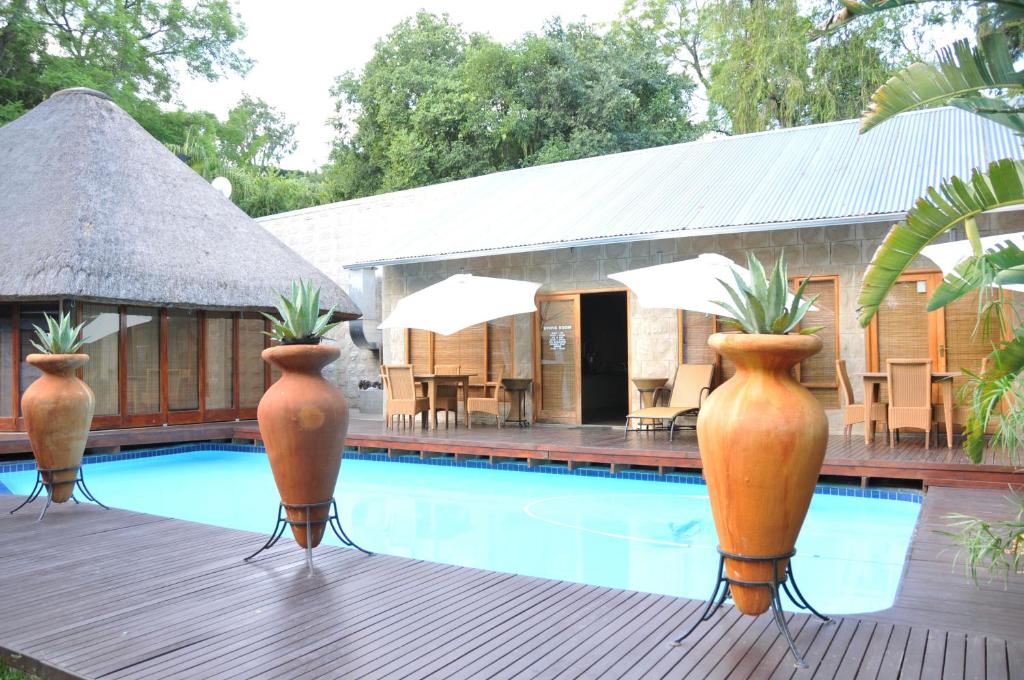 a pool with three large vases with plants in them at Farquhar Lodge in Ladysmith