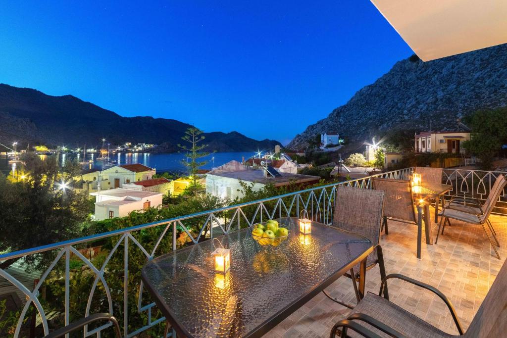 a balcony with a table with fruit on it at Royal Villa Pedi in Symi