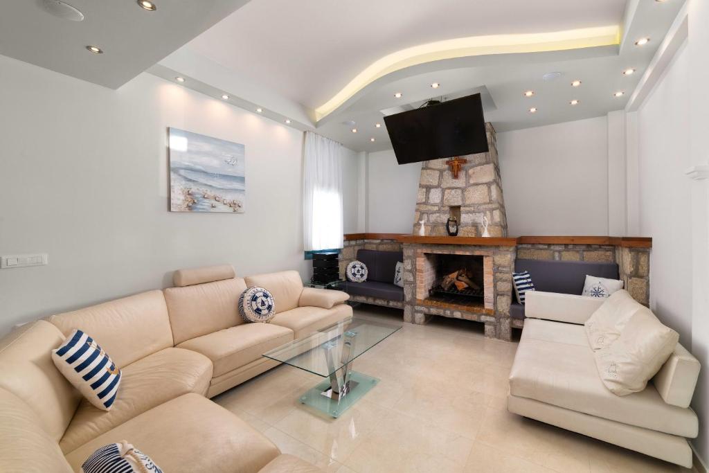 a living room with a couch and a fireplace at Royal Villa Pedi in Symi