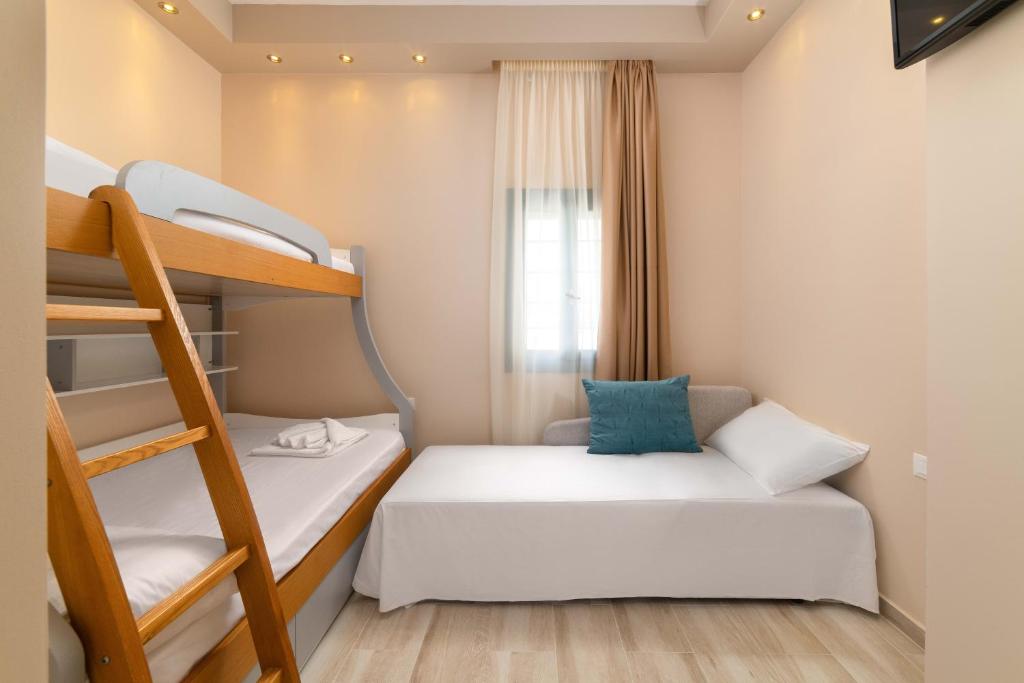 a small room with two bunk beds and a ladder at Royal Villa Pedi in Symi