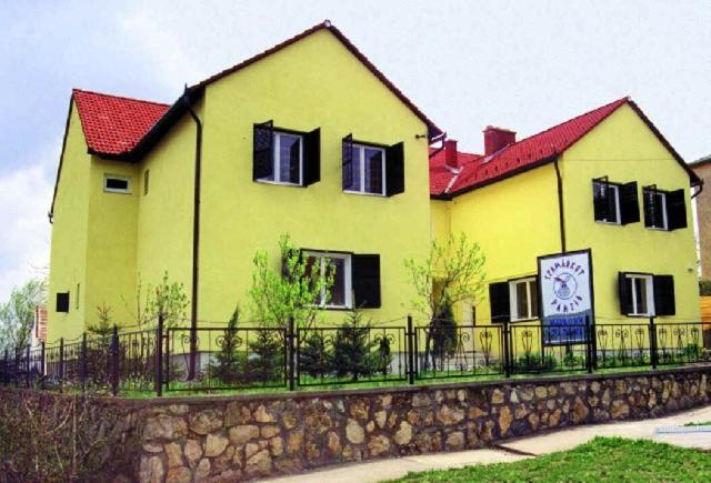 ペーチにあるSzamárkút Panzióの黄色い家