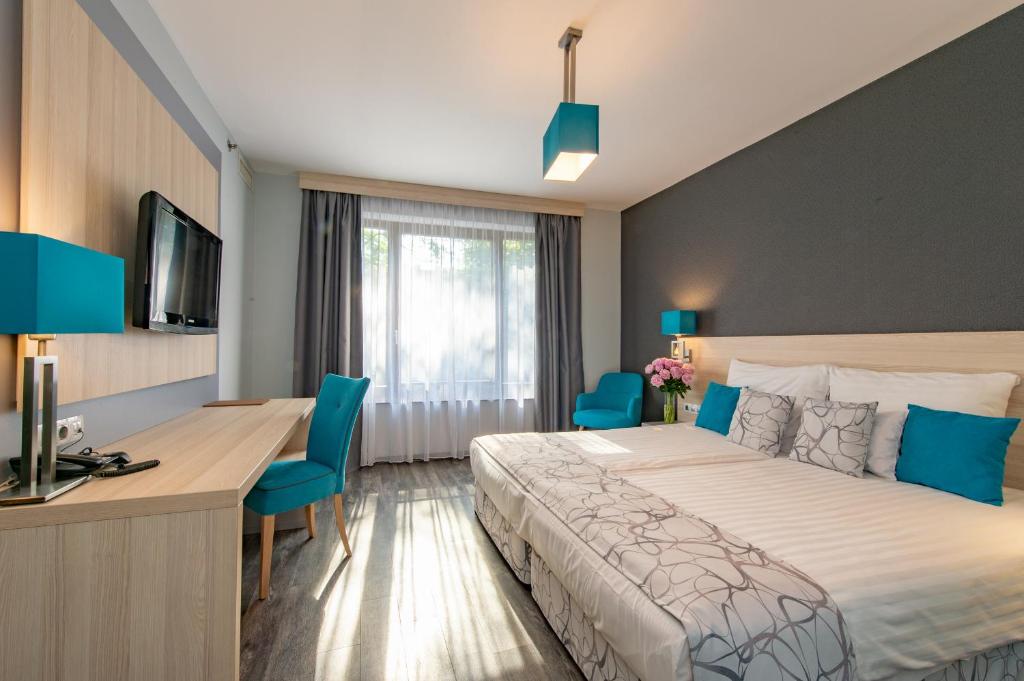 Un pat sau paturi într-o cameră la Hotel Regnum Residence