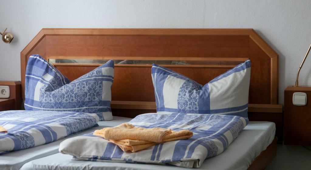 two beds with blue and white pillows in a bedroom at Landhaus Flughafen Messe in Freiroda