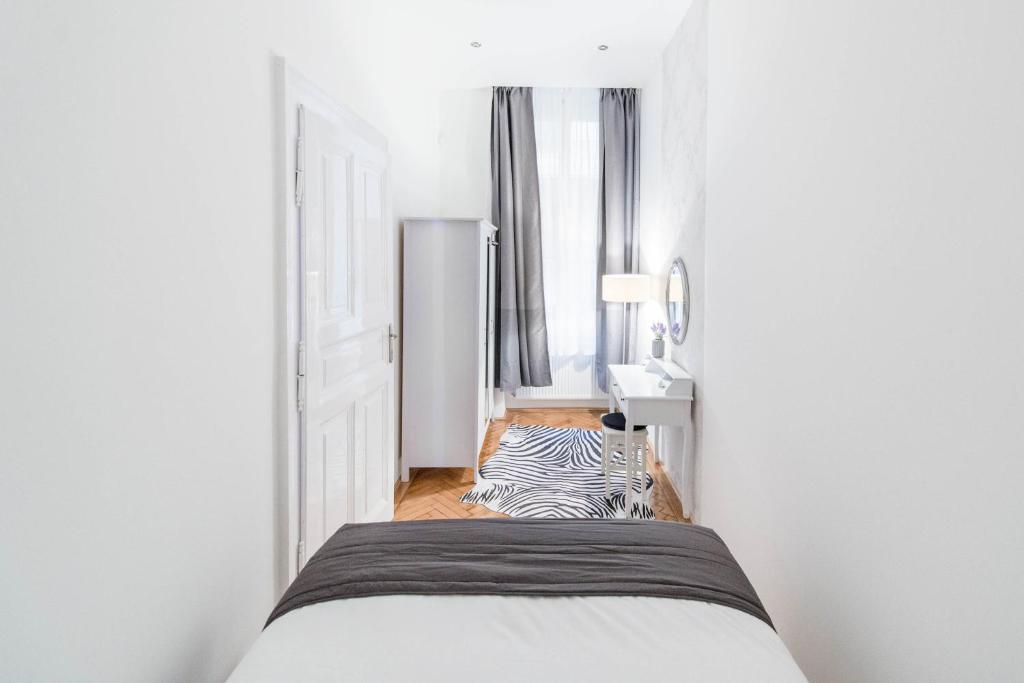 um pequeno quarto com uma cama e uma zebraebraebrainylinylinylinyl em Dominik Apartment em Budapeste