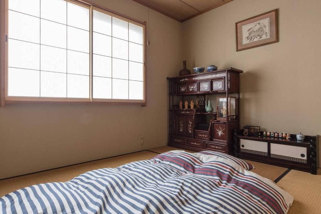 a bedroom with a bed and a large window at Kyoto Fusimi-house #KR1 in Kyoto
