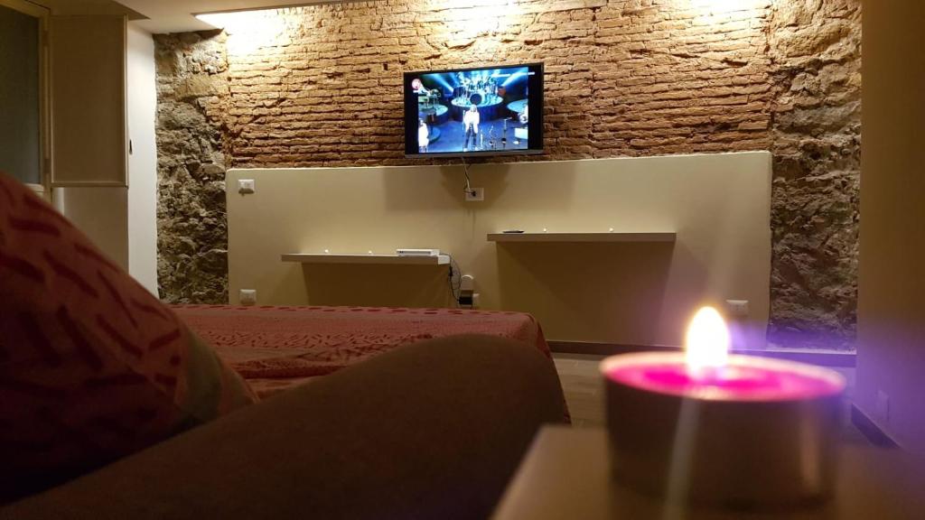 una habitación con una vela y una TV en la pared en Holiday House da Carlo, en Catania