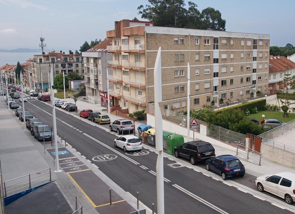 vistas a una calle de la ciudad con coches aparcados en Apartamentos Vacacionales Caracas, en Sanxenxo