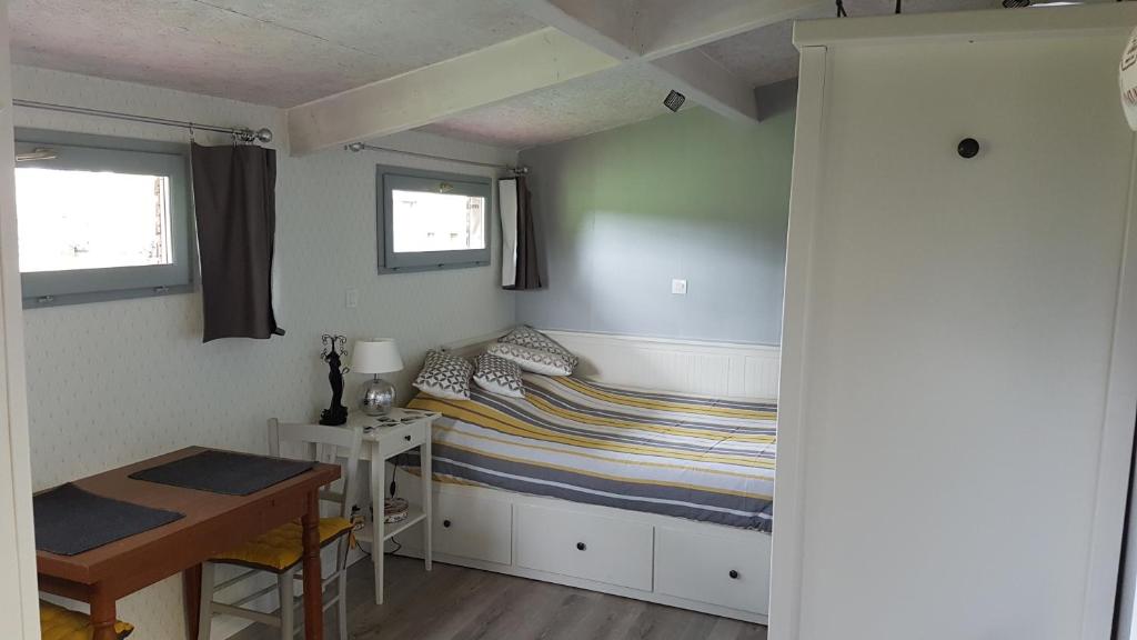 a small bedroom with a bed and a desk at La THIBAUDIERE Tilleul in Châlus
