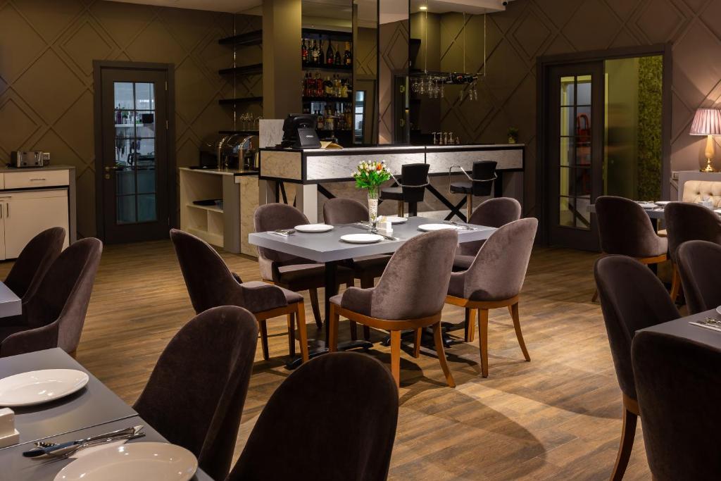 a restaurant with tables and chairs and a counter at Aksent Hotel in Baku