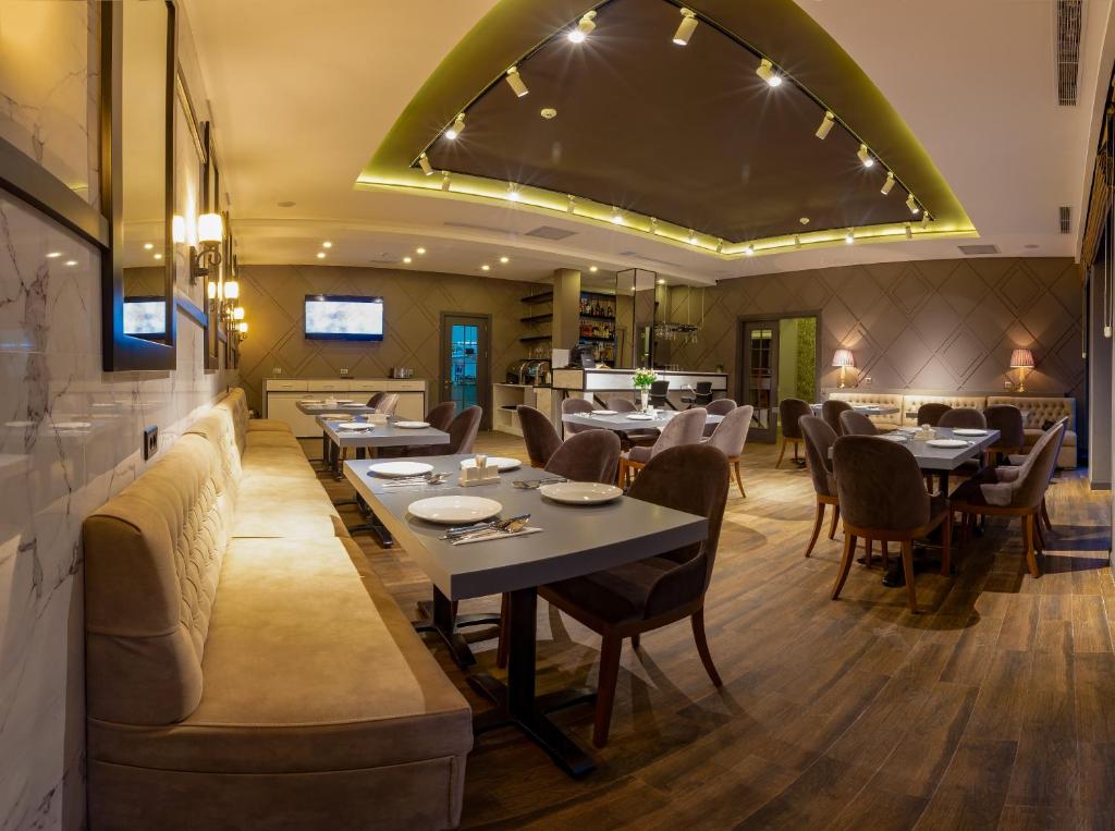 a restaurant with tables and chairs and a bar at Aksent Hotel in Baku