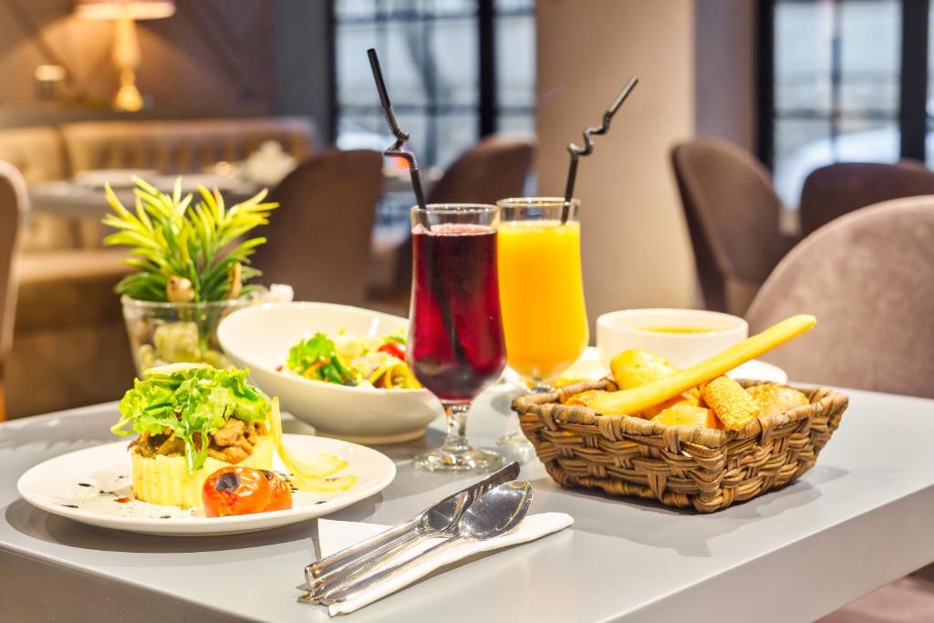 a table topped with plates of food and drinks at Aksent Hotel in Baku