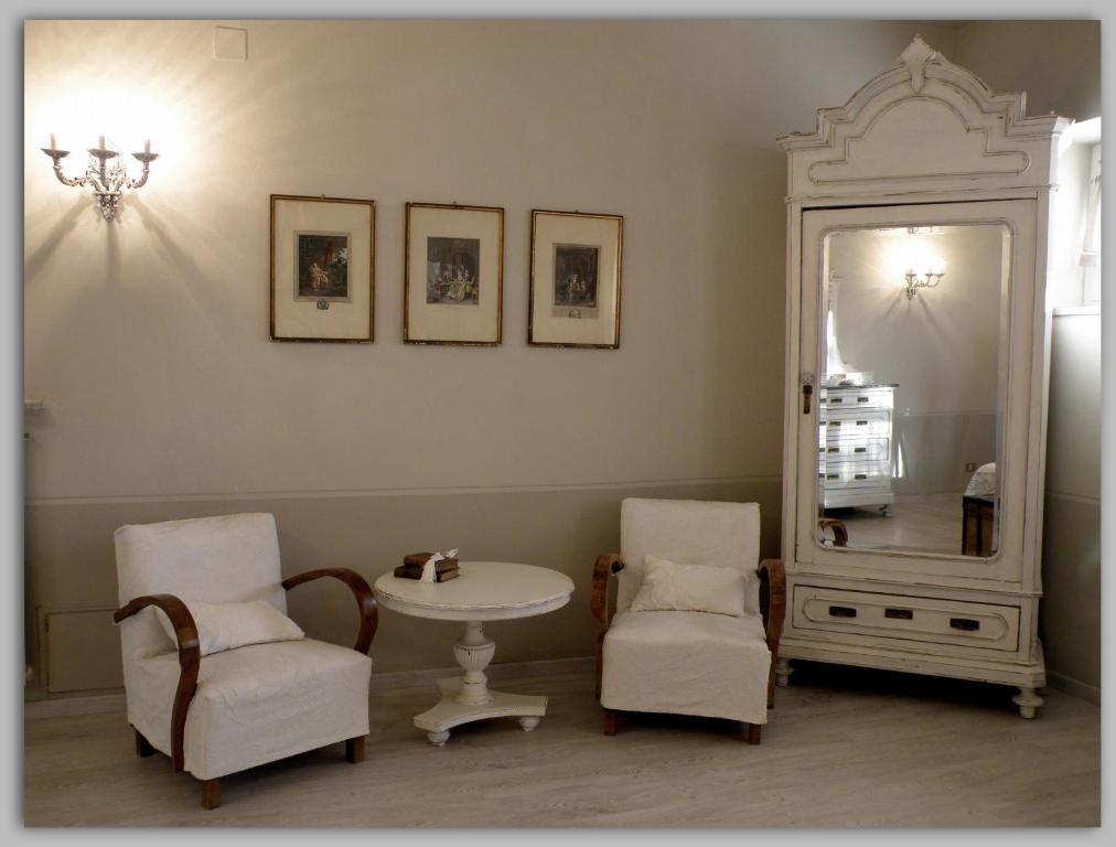 Habitación con mesa, 2 sillas y espejo. en Cascina Luvot en Melazzo