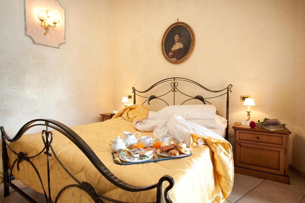 a bedroom with a bed with a tray of food on it at Hotel Villa Torre Antica in Atena Lucana