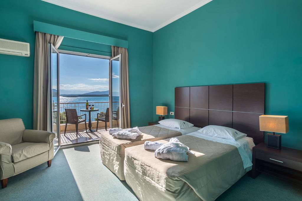 a bedroom with a large bed and a balcony at Galini Hotel in Itea