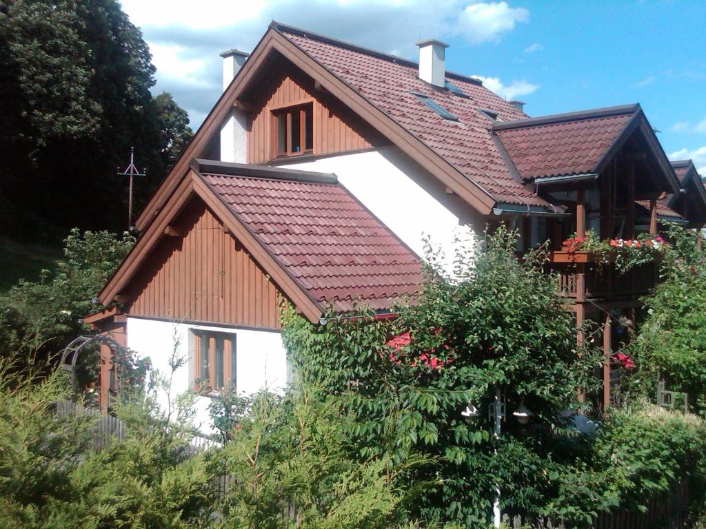 una casa con techo de azulejos encima en Ferienhaus Waldsicht, en Flachau