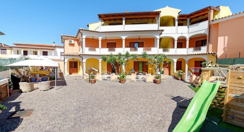 a large building with a playground in front of it at Residence La Corte Di Anastasia in Torpè