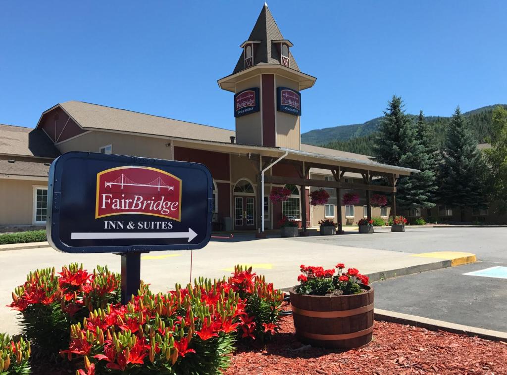 een bord voor een gebouw met bloemen bij FairBridge Inn & Suites Kellogg in Kellogg