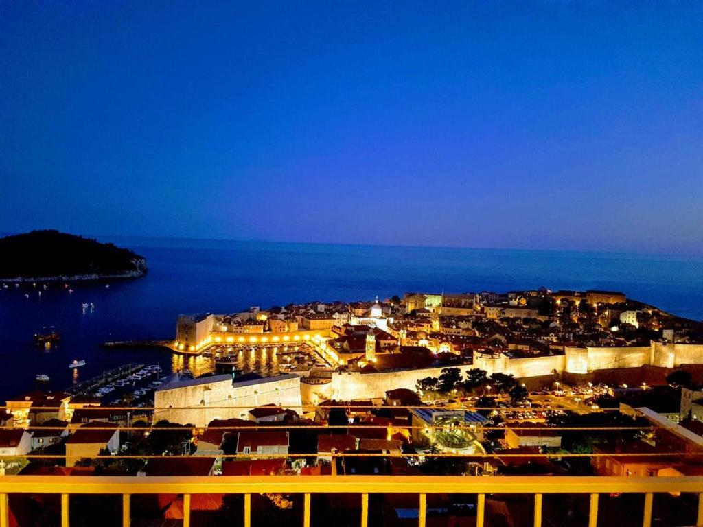 a view of a town at night with the ocean at Apartment Kinkela in Dubrovnik