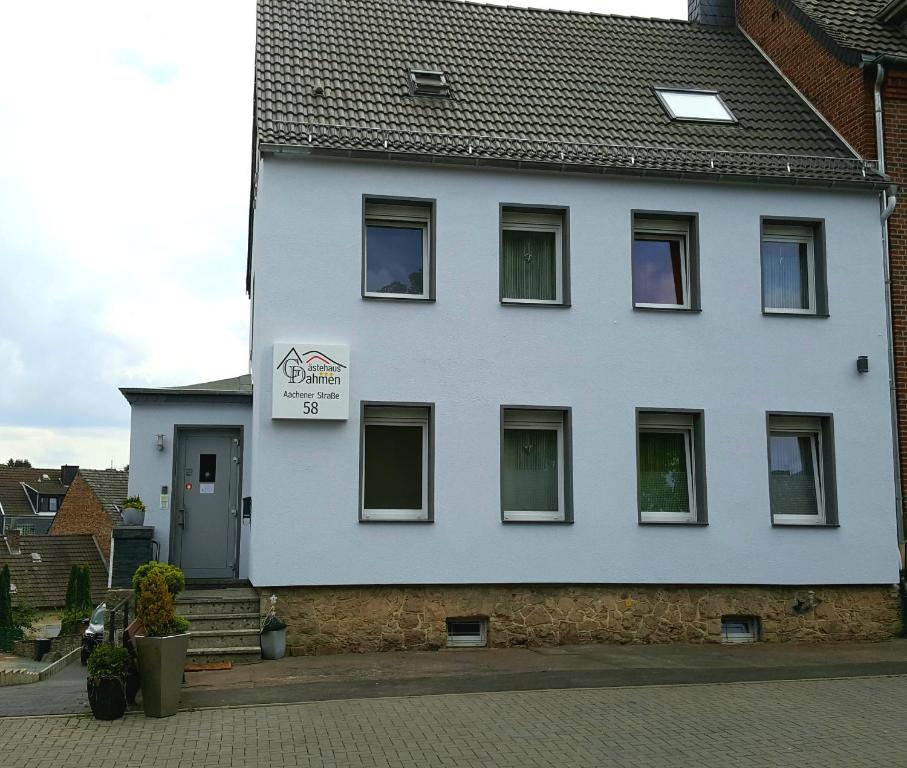 un edificio blanco con un cartel. en Gästehaus Dahmen, en Stolberg