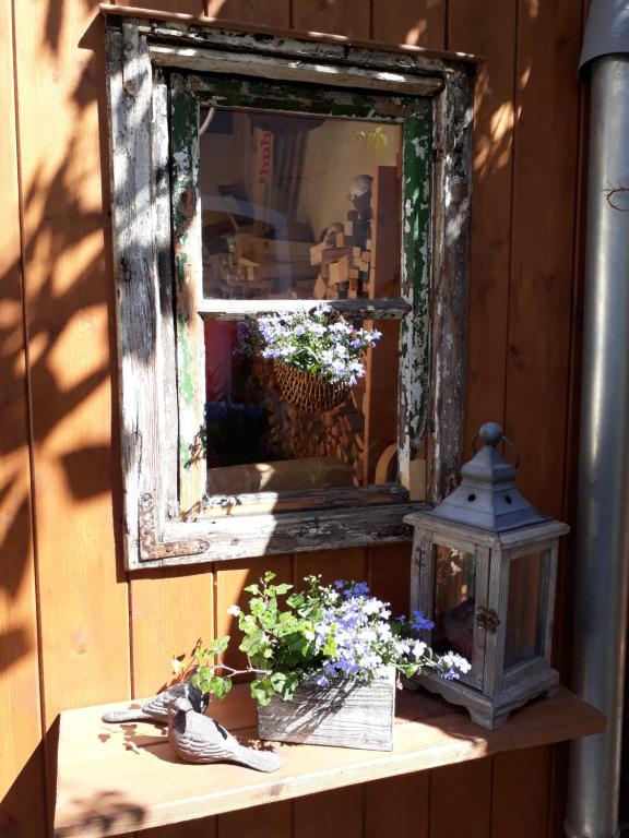 an old mirror sitting on a table with flowers at Apartment Zeitreise in Quedlinburg