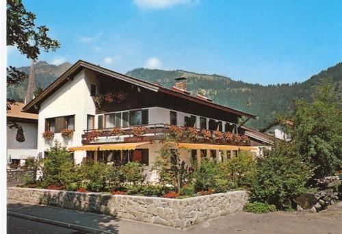 a large house with flowers in front of it at Gästehaus Charlotte in Bayrischzell