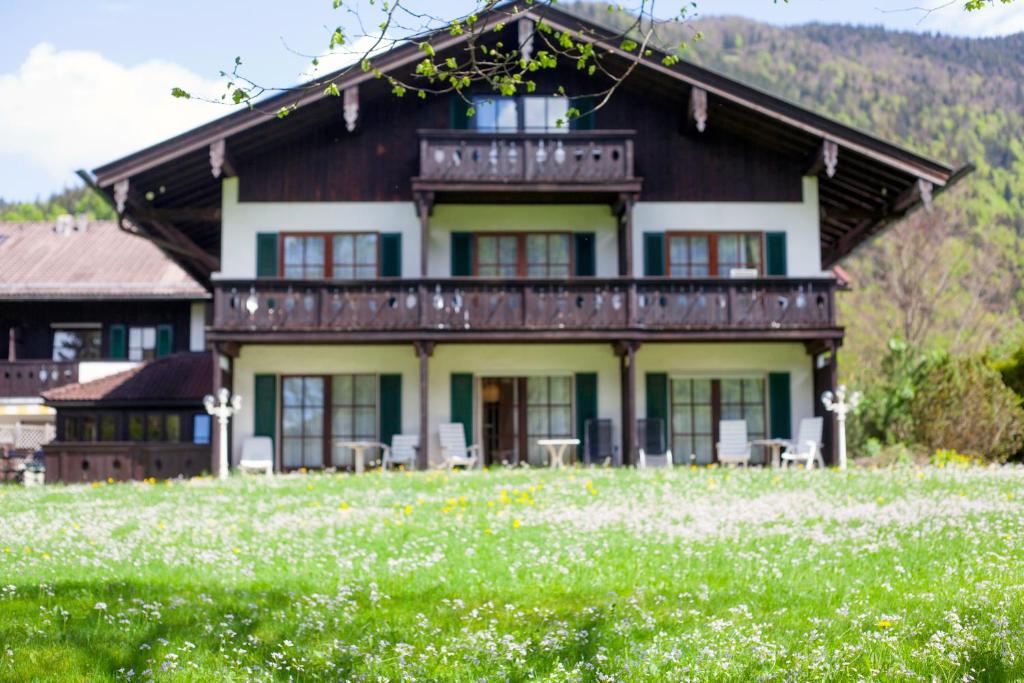 a house on a hill with a field of flowers at Hotel Bachmair Alpina in Rottach-Egern