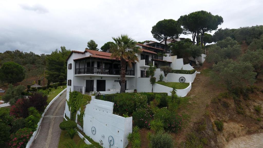 una casa en una colina con una valla blanca en Villa Frideriki, en Agia Paraskevi