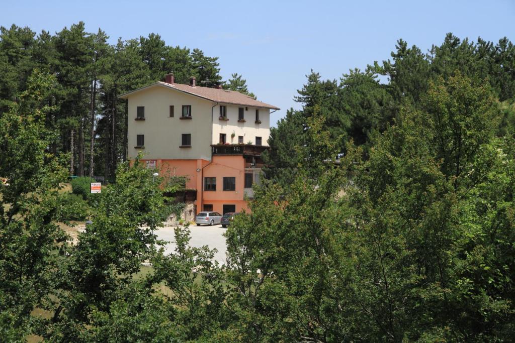 a large white building in the middle of trees at B & B La Pineta By La Capannina in Roccaraso