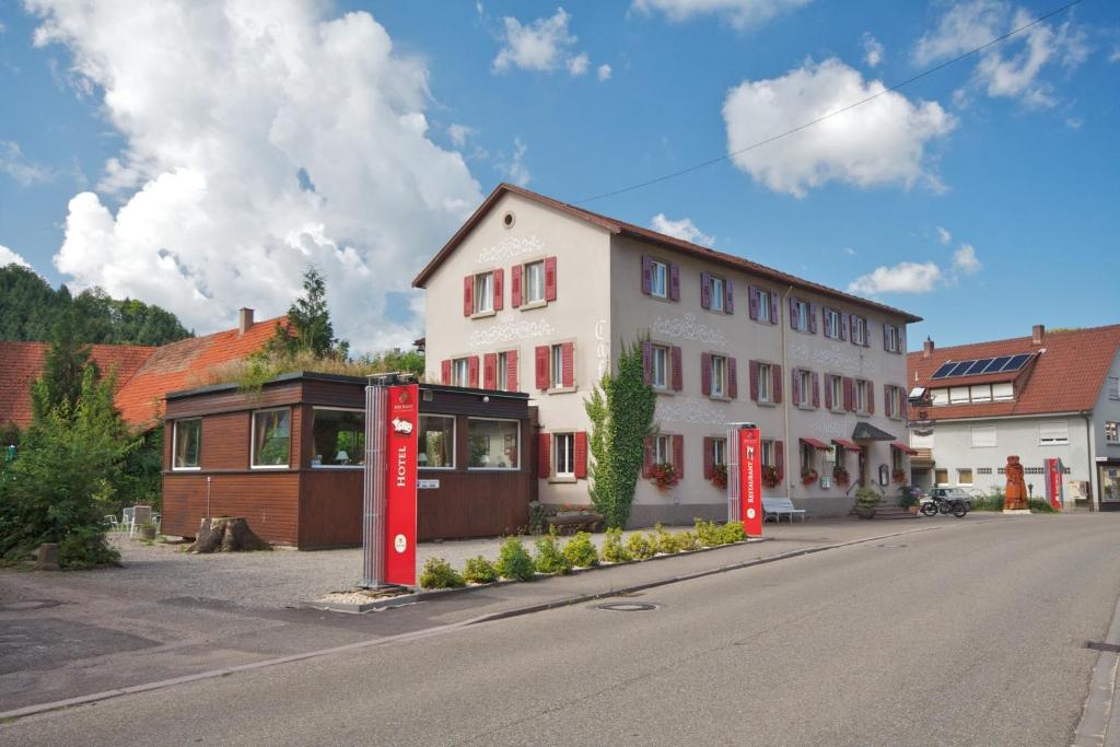 ein Gebäude mit zwei roten Koksmaschinen neben einer Straße in der Unterkunft Gasthof und Pension zum Kreuz in Lautenbach