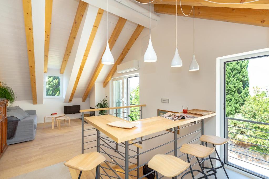 una cucina e un soggiorno con soffitti e sgabelli in legno di Apartment Hedera A56 a Dubrovnik