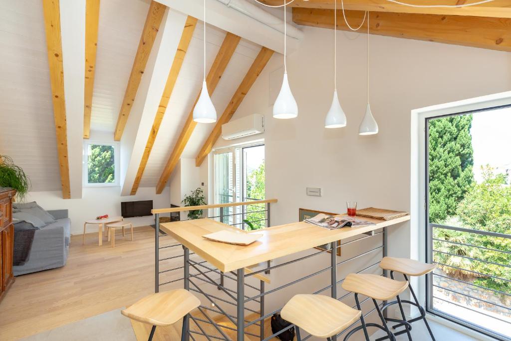 a kitchen and living room with wooden ceilings and wooden stools at Apartment Hedera A56 in Dubrovnik