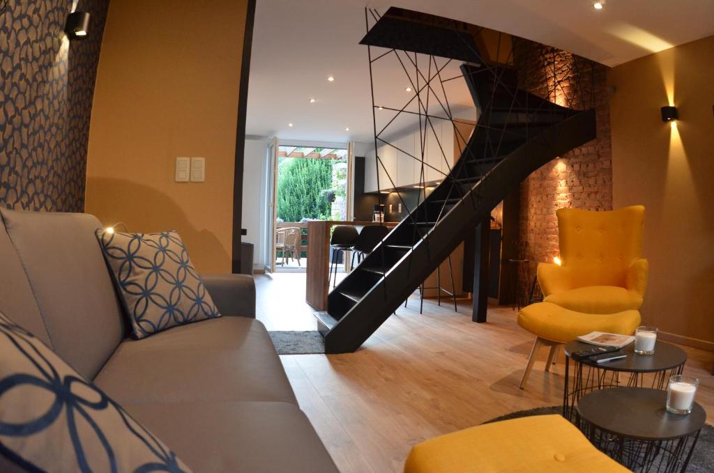 a living room with a staircase and a couch and chairs at 4 rue du Balloir in La Roche-en-Ardenne