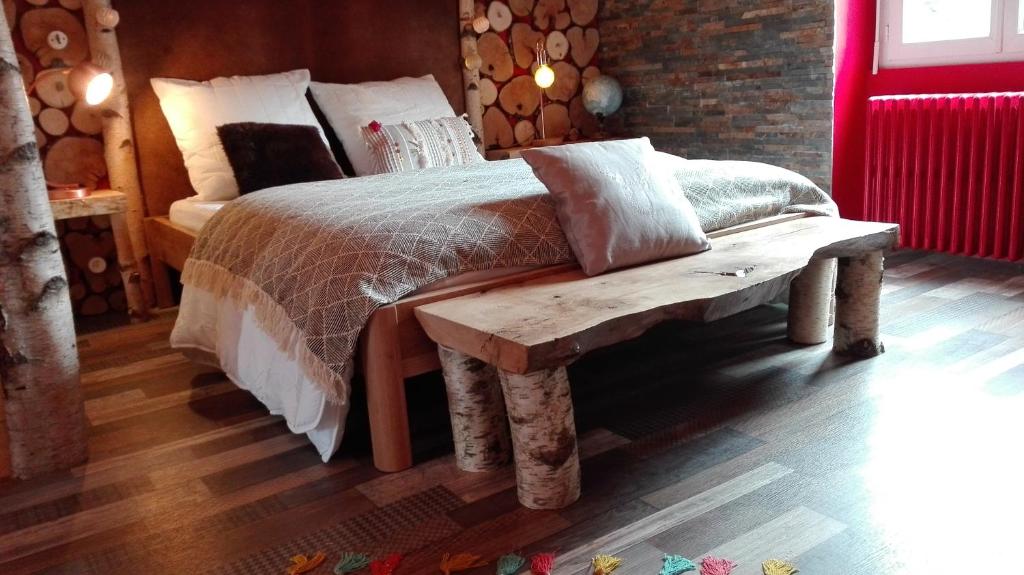 a bed with a wooden bench in a bedroom at Villa Étienne in Le Mont-Dore