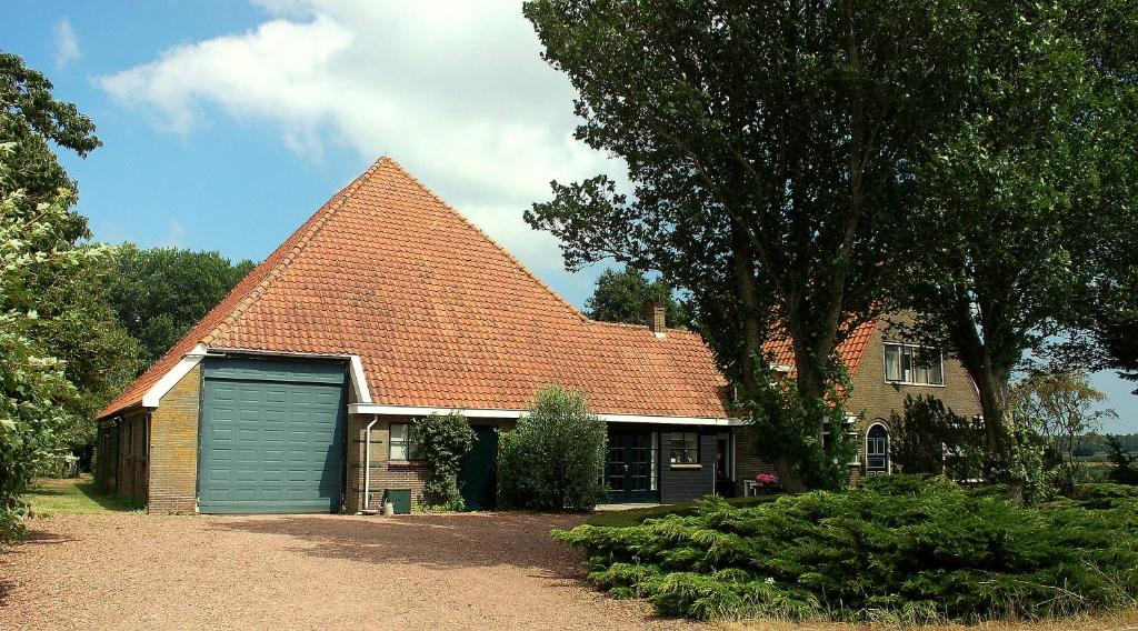 a house with a large roof with a garage at Vita Nova in Hippolytushoef