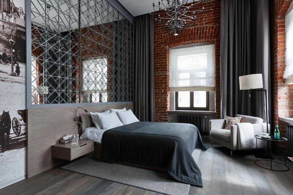 a bedroom with a bed and a brick wall at PR Myasnitsky Boutique Hotel in Moscow