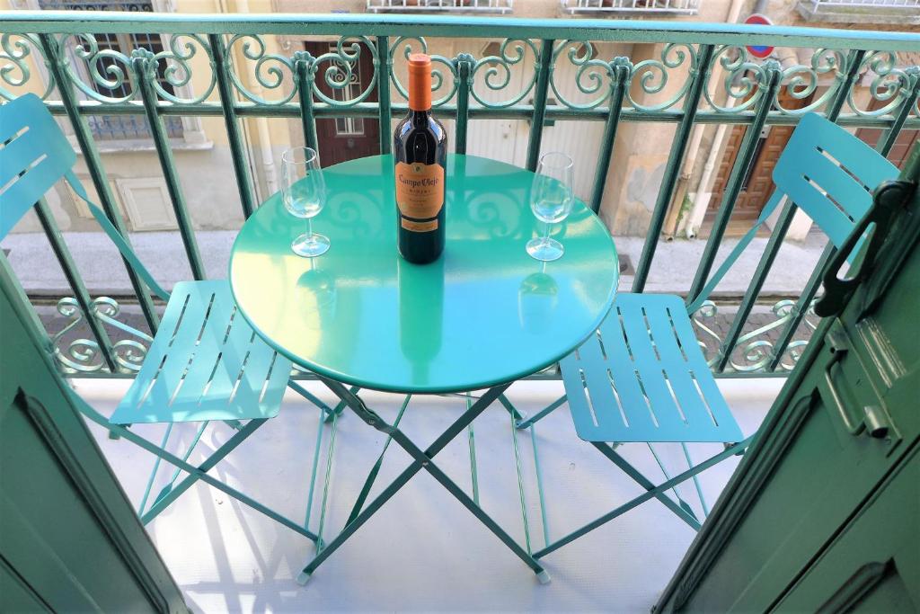 Ceret Pyrenean Star في كريت: زجاجة من النبيذ موضوعة على طاولة مع كرسيين